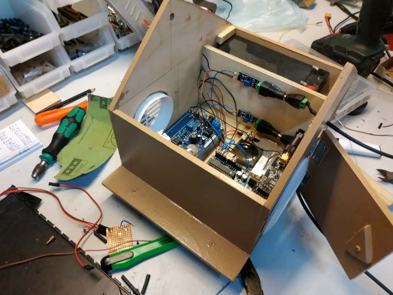 The picture shows the open casing of SAM in which a few cables and sensors can be seen. It was taken right in the middle of assembling it as there’s tools surrounding the workspace.